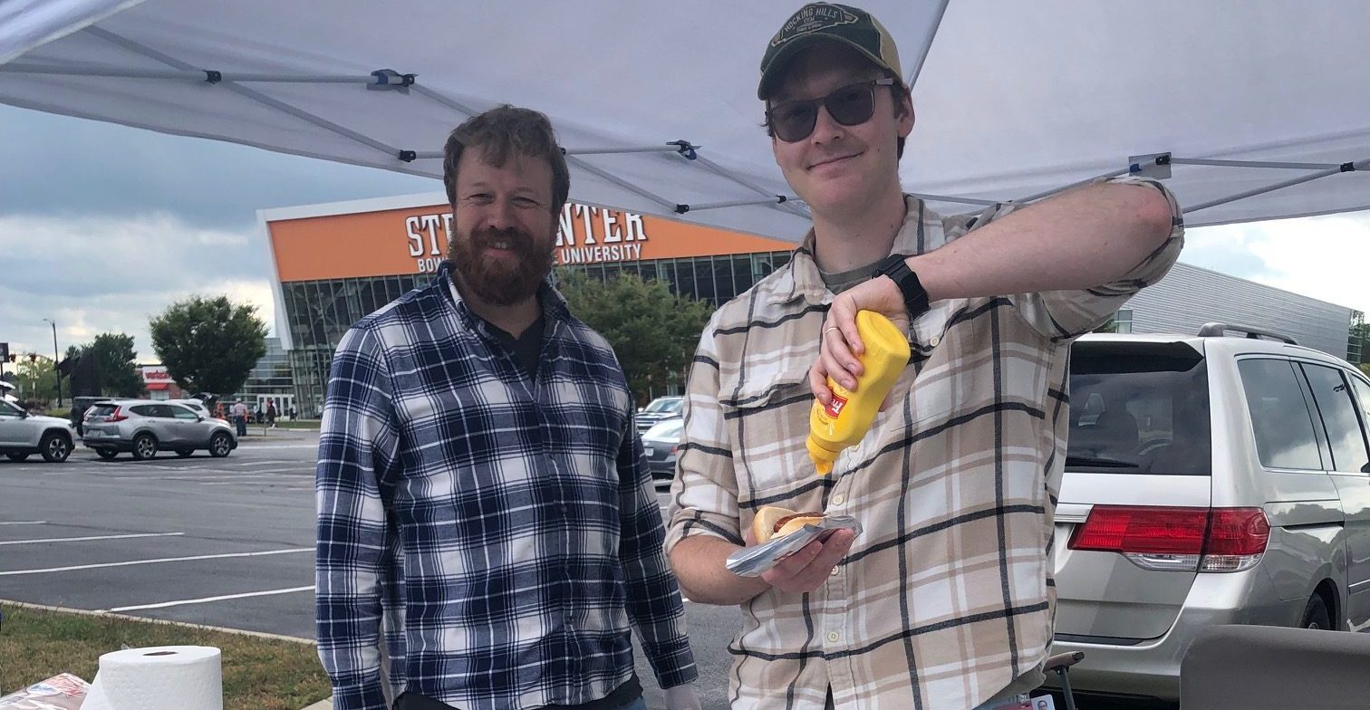 person reading book beside white ceramic mug with coffee